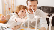 Vater und Sohn betrachten die Miniaturnachbildung eines Windparks